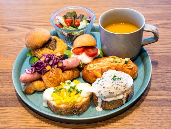 6種類のパンが載った「パンの盛り合わせプレート」の写真。4種目からはプラス料金で追加可能。