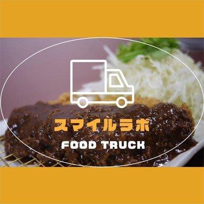 スマイルラボの店舗ロゴ。背景に味噌カツの写真。