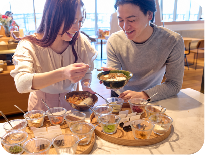 カップルがカレーのトッピングを選んでいる様子