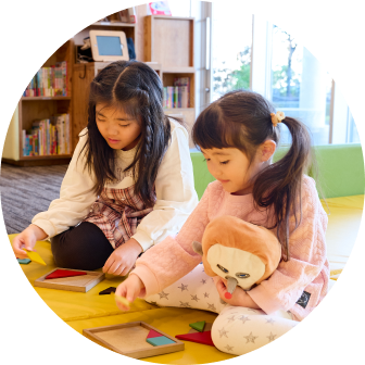 マンガ・ラノベ図書館のキッズコーナーで遊んでいる姉妹の様子